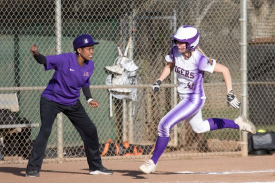 Lemoore's Megan Van Allen, in a game a year ago, is urged to run home by Tiger Coach Dionne Ewing. Van Allen, a senior returns for the Tigers.
